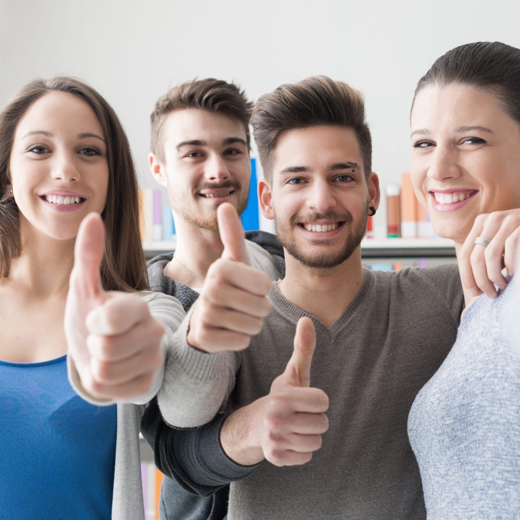 Cheerful students with thumbs up